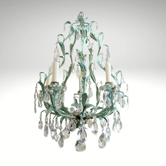 A vintage teal and gold leaf chandelier adorned with hanging crystal teardrops.