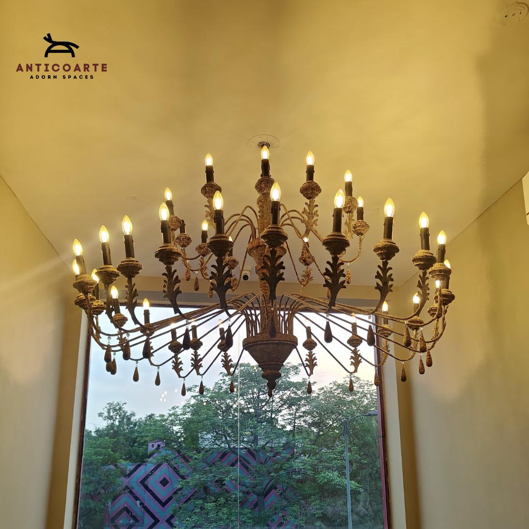 Anticoarte - Decorative chandelier hanging in a room with a window view of trees